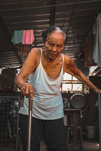 Portrait of woman standing with walking cane