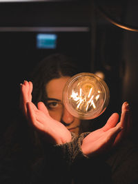 Close-up portrait of hand holding illuminated lighting equipment