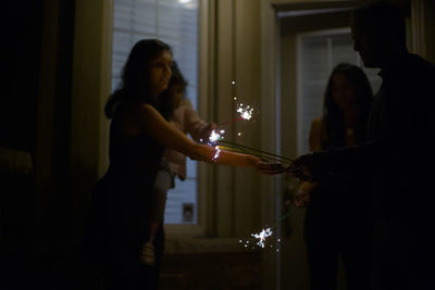 Side view of woman with sparklers 