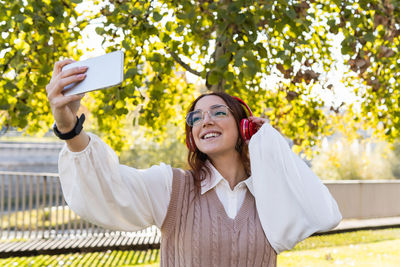 Cheerful woman doing selfie outdoors