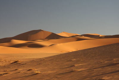 Sand dune in desert against clear sky