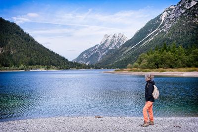 Boy on lake against sky