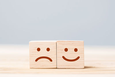 Close-up of smiley face on table against white background