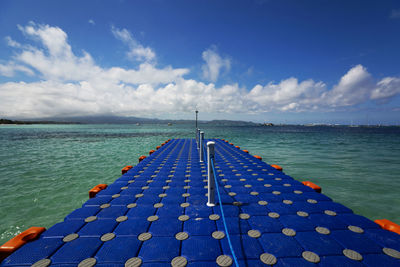 View of swimming pool by sea against sky