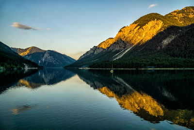 Scenic view of lake by mountain against sky