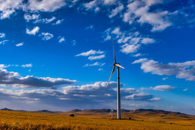 Windmill on field against sky