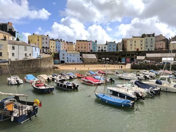 Boats moored in city against sky