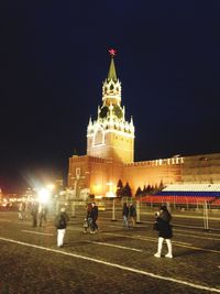 People at illuminated city lit up at night