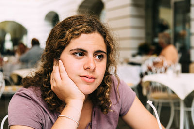 Beautiful woman looking away while sitting in cafe
