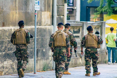 Rear view of soldier walking on street