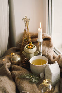 Hot tea, candles, christmas golden balls and decorations. christmas holiday mood.