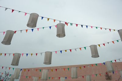 Low angle view of flags hanging against sky