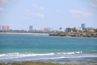 Scenic view of sea by city against sky