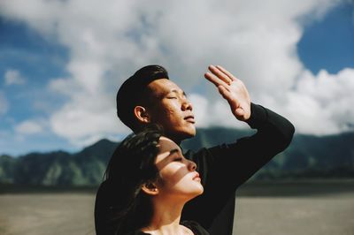 Young man looking at camera against sky