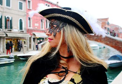 Woman venetian mask standing by canal