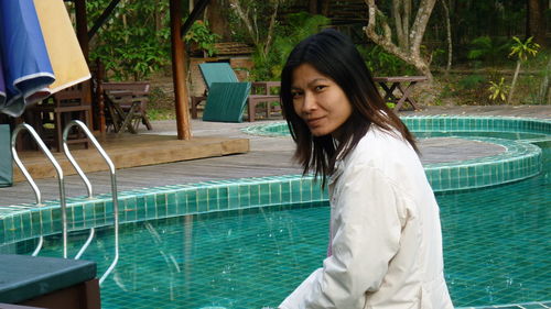 Portrait of smiling mature woman by swimming pool