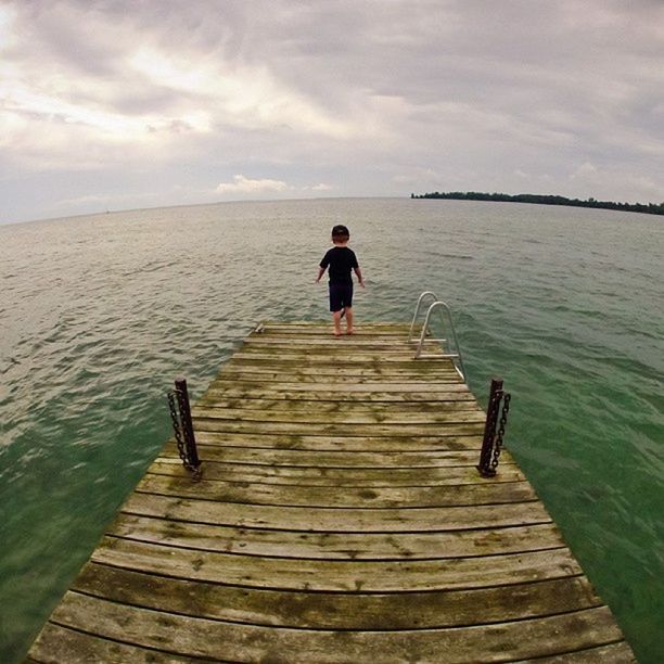 water, pier, sky, rear view, wood - material, tranquility, tranquil scene, the way forward, full length, sea, jetty, scenics, boardwalk, nature, cloud - sky, lifestyles, beauty in nature, standing