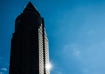 Low angle view of modern building against blue sky