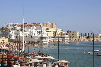 Boats in harbor against clear sky