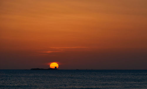 Scenic view of sea against orange sky