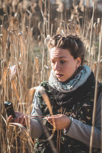 Side view of young woman standing on field