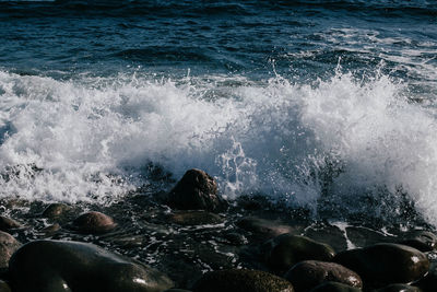 Waves splashing on rocks at sea shore