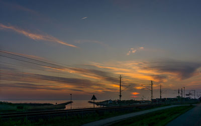 Railroad tracks against sky during sunset