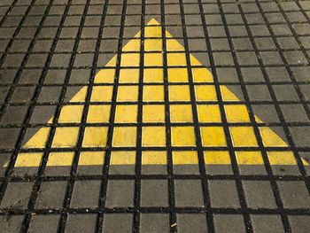 High angle view of yellow paving stone on footpath