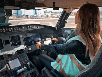 Rear view of woman sitting in airplane