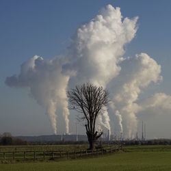 Smoke emitting from industry against sky