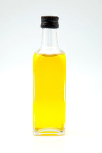 Close-up of yellow bottle against white background
