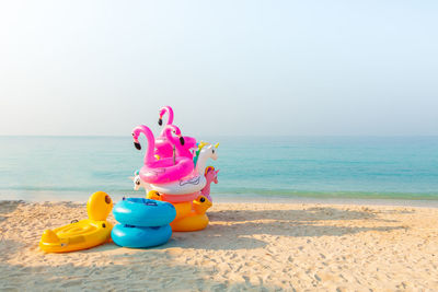 Toys on beach against clear sky