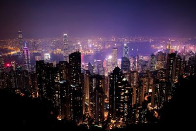 Illuminated cityscape against sky at night