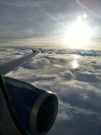 Cropped image of airplane wing over clouds