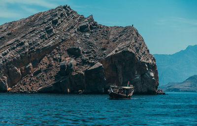 Sailboat on rock by sea against sky