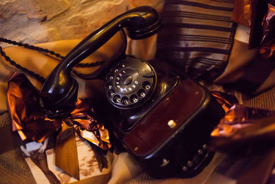 High angle view of rotary phone on furniture with wrapping papers