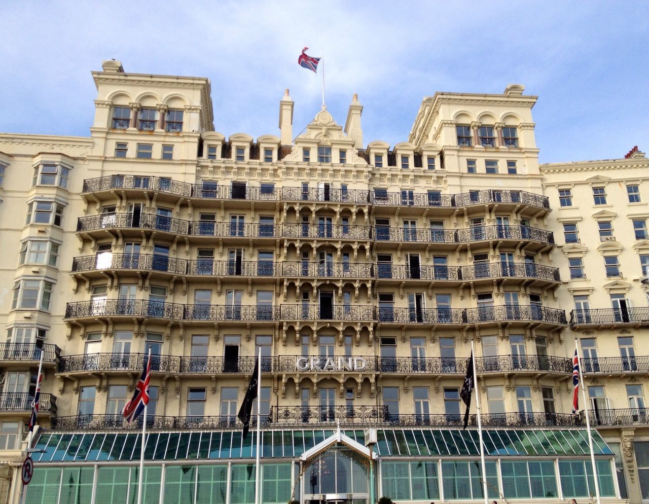 building exterior, architecture, built structure, low angle view, city, window, building, sky, city life, day, modern, office building, facade, residential building, travel destinations, outdoors, flag, capital cities, no people, tall - high