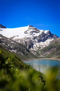 Scenic view of snowcapped mountains against clear blue sky