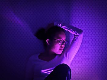 Woman sitting in illuminated room