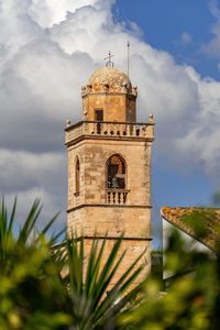 Low angle view of bell tower amidst buildings against sky
