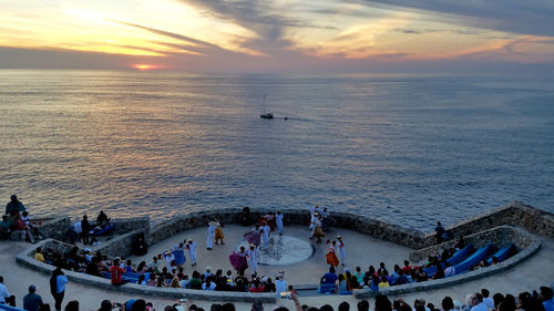 High angle view of people on sea against sky during sunset