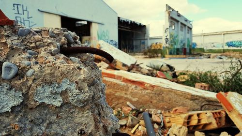 Close-up of abandoned rusty against sky