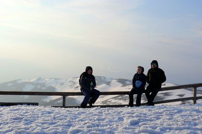 People on snow covered mountain against sky