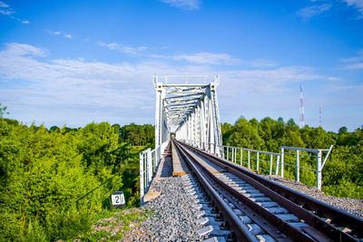 Railroad tracks by bridge against sky