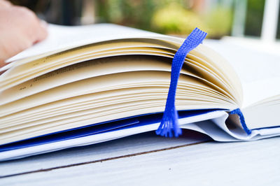 Cropped image of hand with book on table