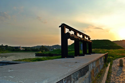 Bridge over river against sky during sunset