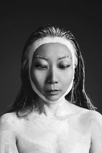 Asian woman with cray mask on hair and face