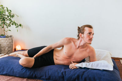 Young man lying on bed