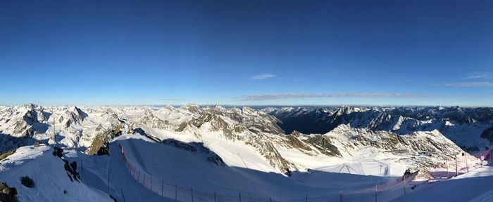 Scenic view of snowcapped mountains against blue sky