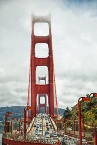 View of suspension bridge against cloudy sky